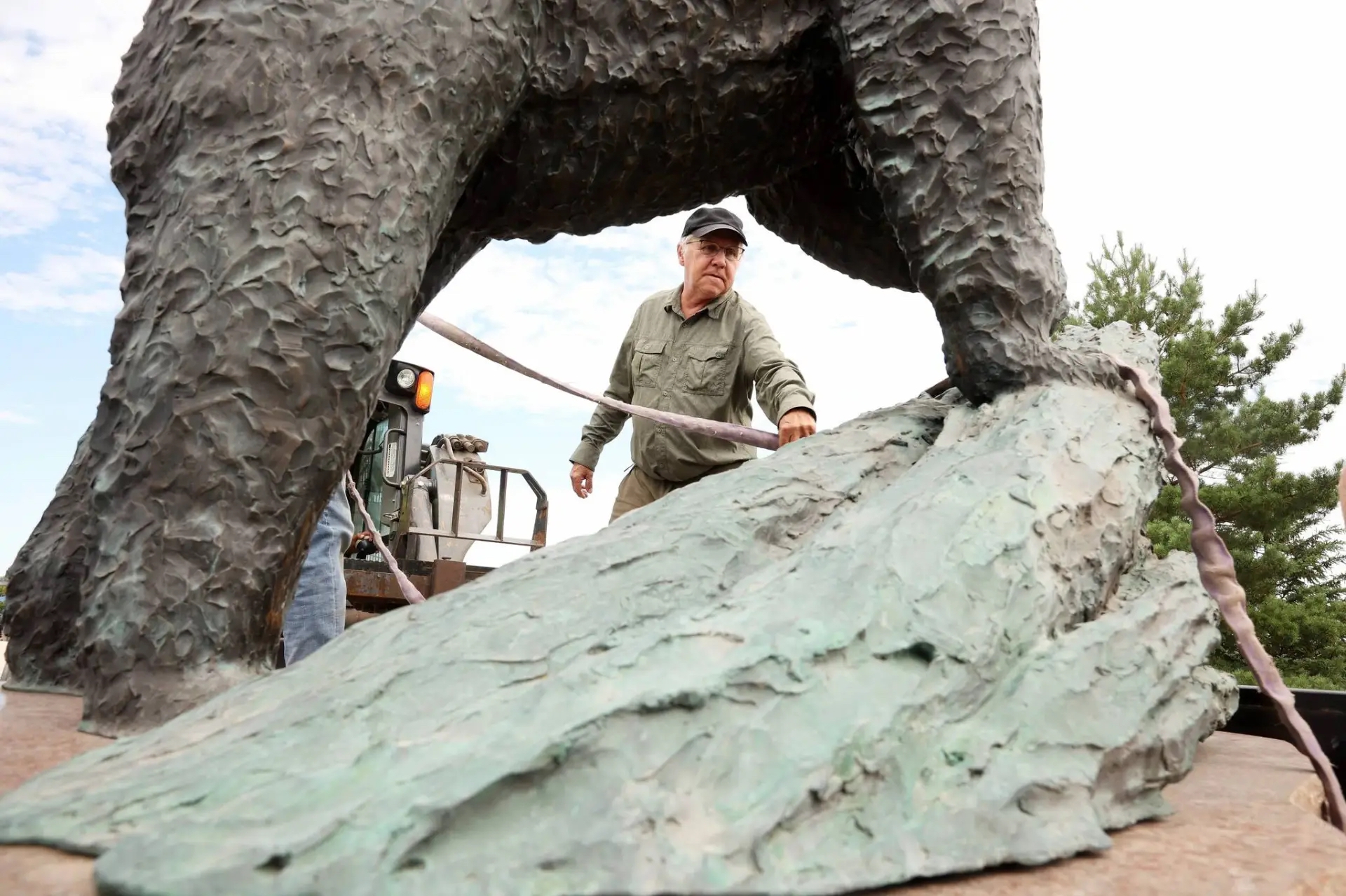 Peter Sawatzky installs his bronze sculpture of a black bear
