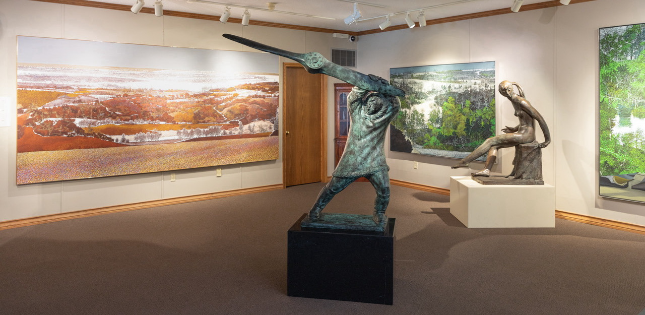 Photograph of art gallery with paintings and sculptures
