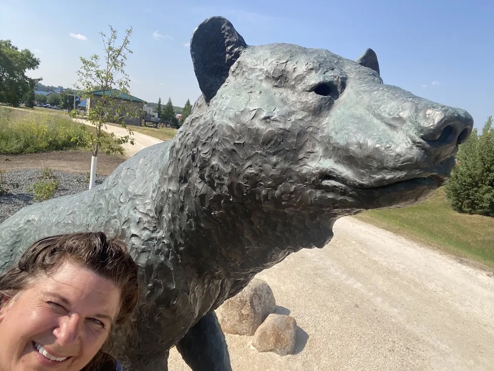 Woman takes a selfie in from of the large bronze bear sculpture